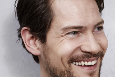 Man smiling promoting surgical laser eyelid surgery treatment
