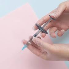 Hand with syringe for skinbooster injection treatment